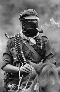 Subcomandante Marcos, the spokesman of the Ej&eacute;rcito Zapatista de Liberaci&oacute;n Nacional, smoking a pipe atop a horse in Chiapas, Mexico