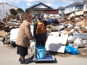 A Peace Boat volunteer helps in the aftermath of the earthquake/tsunami; photo by Jon Mitchell