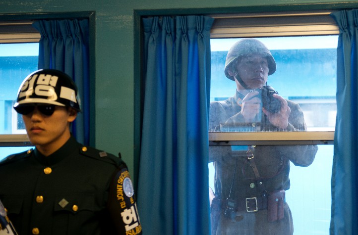 A North Korean Soldier takes photos through the window while U.S. Army Gen Martin E. Dempsey, chairman of the Joint Chiefs of Staff, is briefed at the demilitarized zone in South Korea, Nov. 11, 2012. (DOD photo by D. Myles Cullen/Released)