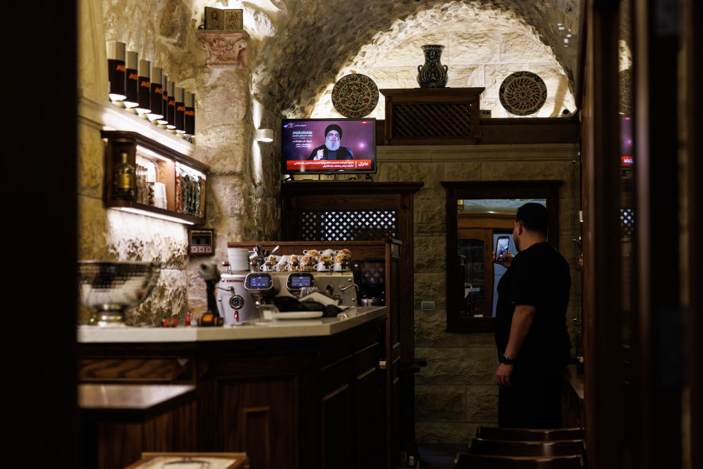 A man in Jerusalem's Old City watches a speech by Hezbollah leader Hassan Nasrallah, who was recently assassinated by Israel, in November 2023. (Getty)