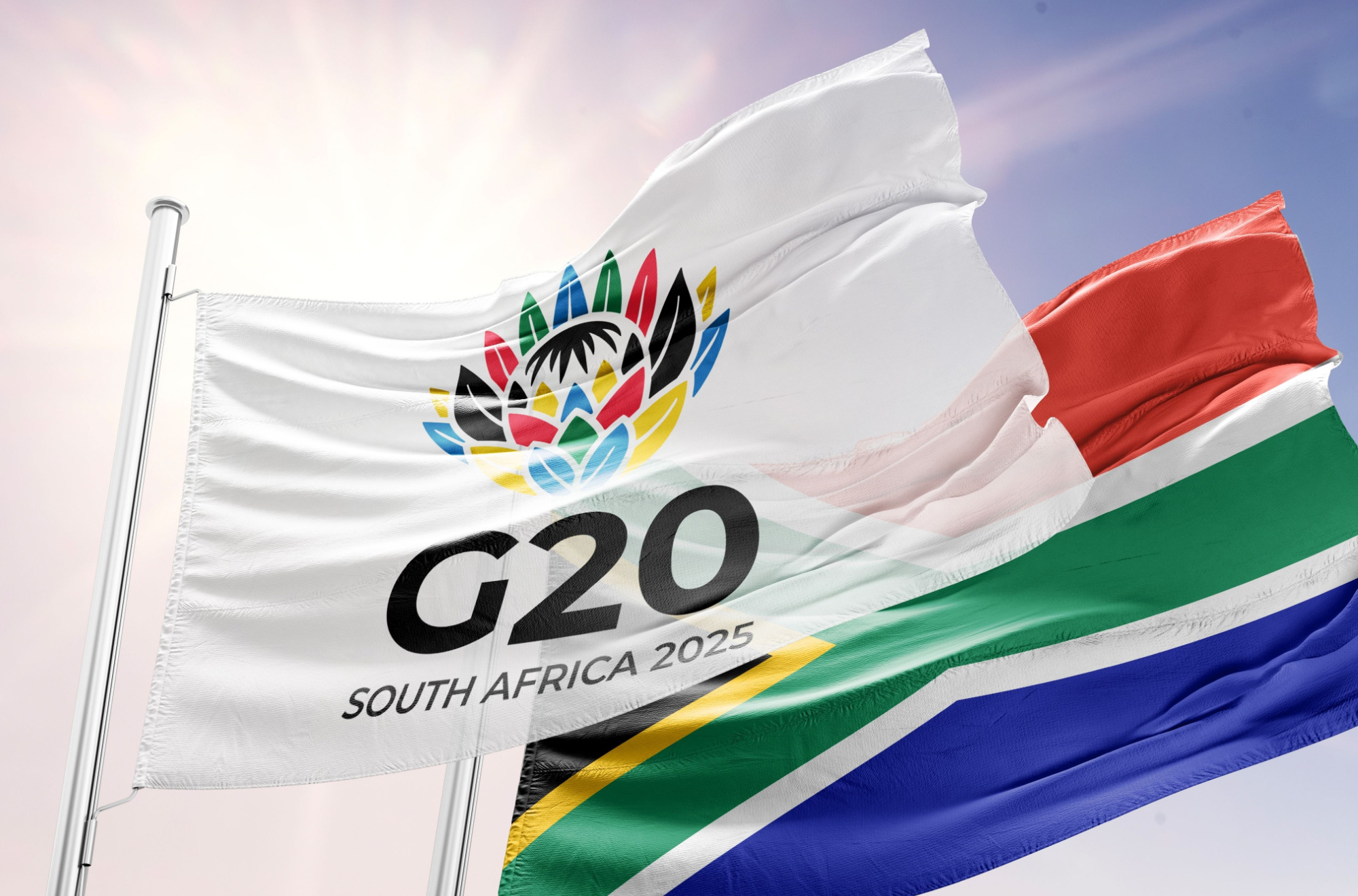 A G20 and South African flag fly together in the wind.